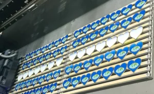 Rows of heart-shaped lapel pins with blue gradients prepared for UV printing, illustrating layout before detailed printing begins